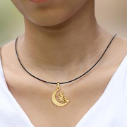 Black necklace with a gold-plated moon pendant featuring...