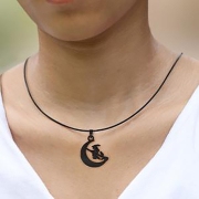 Black necklace with a moon pendant featuring a witch on a...