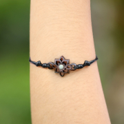 Black bracelet with a square flower motif and blue opal,...
