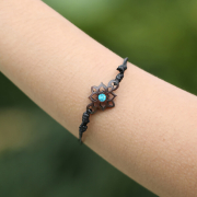 Black bracelet with a square flower and a turquoise...