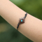 Black bracelet with a square flower and a turquoise stone, made of narra wood